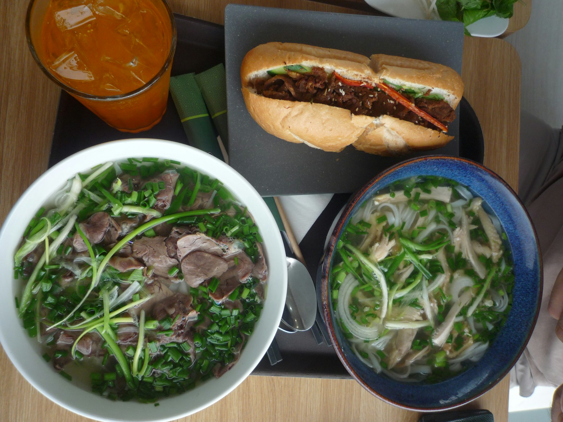 Vietnamese meal with phở, bánh mì and orange juice